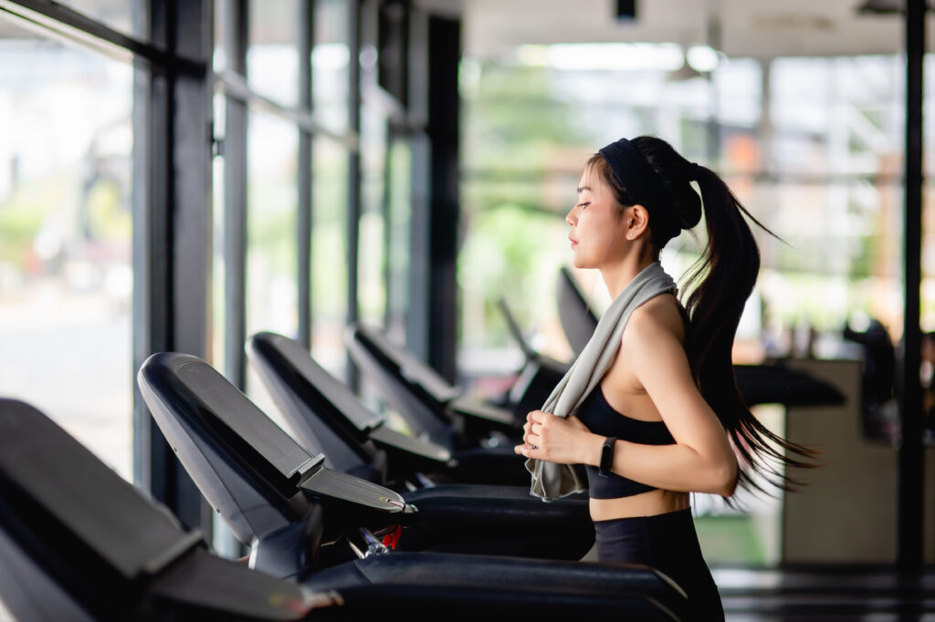 Kenapa Kita Harus Olahraga? Ini Jawabannya! young woman running on treadmill to workout in gym